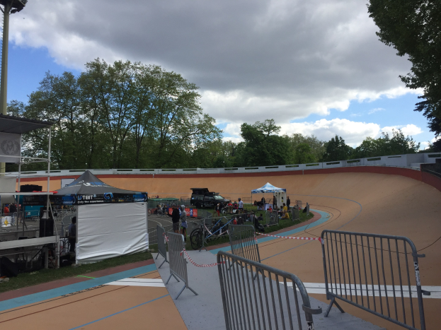 Gruppe von Radfahrern auf einer Schmutz BMX-Strecke mit Zuschauern, Zelten und Fahrzeugen im Hintergrund während der 2018 UCI BMX-Weltmeisterschaften.