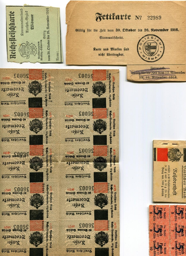 Sammlung alter deutscher Tickets und Marken auf weißem Hintergrund, einige mit gedrucktem Text und Zahlen.