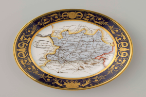 Eine weiße Kennzeichenplatte mit einer detaillierten Deutschlandkarte, verziert mit kunstvollen Designs und Text.