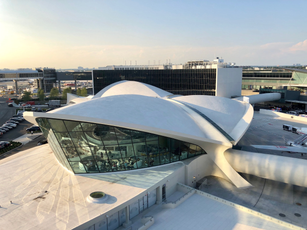 Luftaufnahme des neuen Terminalgebäudes am Los Angeles International Airport mit umliegenden Straßen, Fahrzeugen, Bäumen und Gebäuden unter einem bewölkten Himmel.