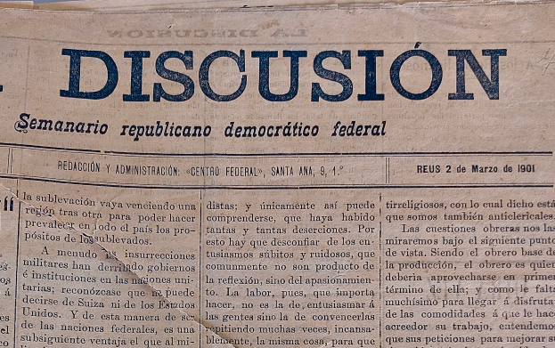 Eine gelbliche, leicht zerknitterte Zeitung mit der schwarzen Schrift 'Diskussion', die die Schlagzeile 'Semanario Repúblicano Democrático Federal' trägt.