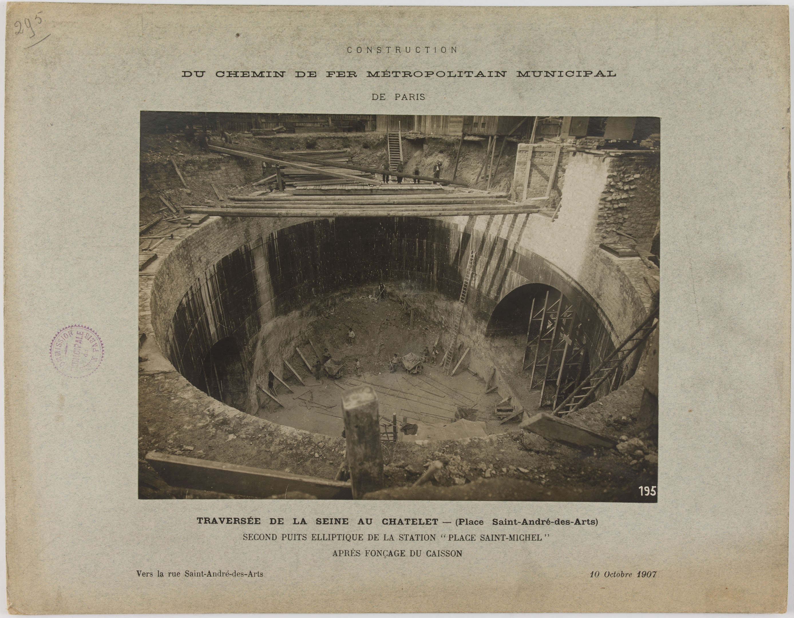 Schwarz-weiß-Foto eines Tunnelbaus mit einem Stempel links und Text unten.