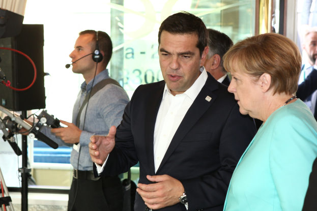 Zwei deutsche Bundeskanzler, Angela Merkel und Joachim Gauck, stehen sich vor einer Glaswand mit einem Vorhang dahinter gegenüber, beide tragen Anzüge und sind mit Mikrofonen ausgestattet.