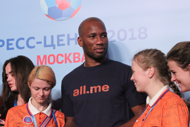 Eine Gruppe von Menschen mit Medaillen steht auf einer Bühne mit einem Banner, das Text und einen Fußball im Hintergrund zeigt, was die 2018 FIFA-Weltmeisterschaft Russland anzeigt.