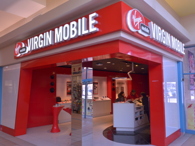 Ein Virgin Mobile Store in einem Einkaufszentrum mit Menschen davor, mit einer Glastür auf der rechten Seite und Deckenbeleuchtung.