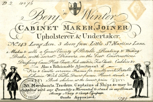 Ein altes Geschäftsvisitenkarte mit einem Mann im blauen Anzug, weißem Hemd und roter Krawatte mit ernstem Gesichtsausdruck, mit dem Text "Ben in Winter Schreiner, Tischler, Polsterer & Bestatter" und einem Logo.