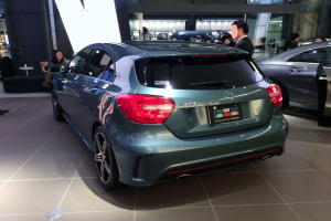 Ein Mercedes-Benz A-Klasse Hatchback auf der IAA in Frankfurt, ein schlankes, modernes Design mit glänzender schwarzer Lackierung, Chromakzente, sportliches Aussehen, niedriger Profil, breite Basis, geräumiger und bequemer Innenraum mit Lederausstattung, markantes Kühlergrill und Aluminiumräder.