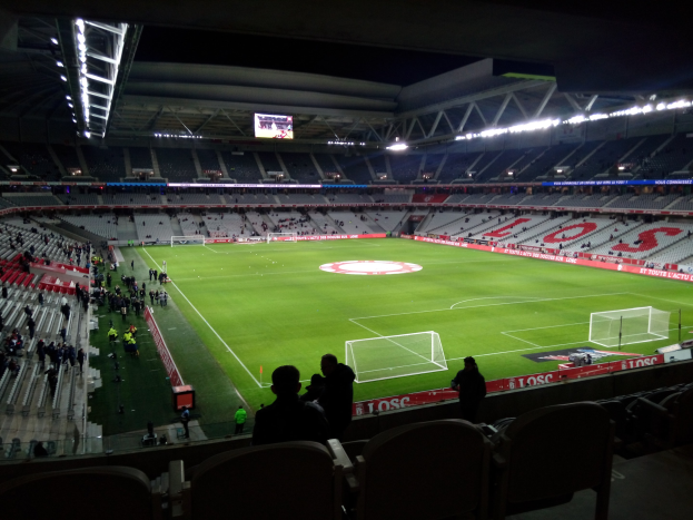 Großes Stadion voller Zuschauer bei einem Fußballspiel im Estadio Santiago Bernabéu in Madrid, Spanien, unter Stadionbeleuchtung mit einem Bildschirm über dem Feld.